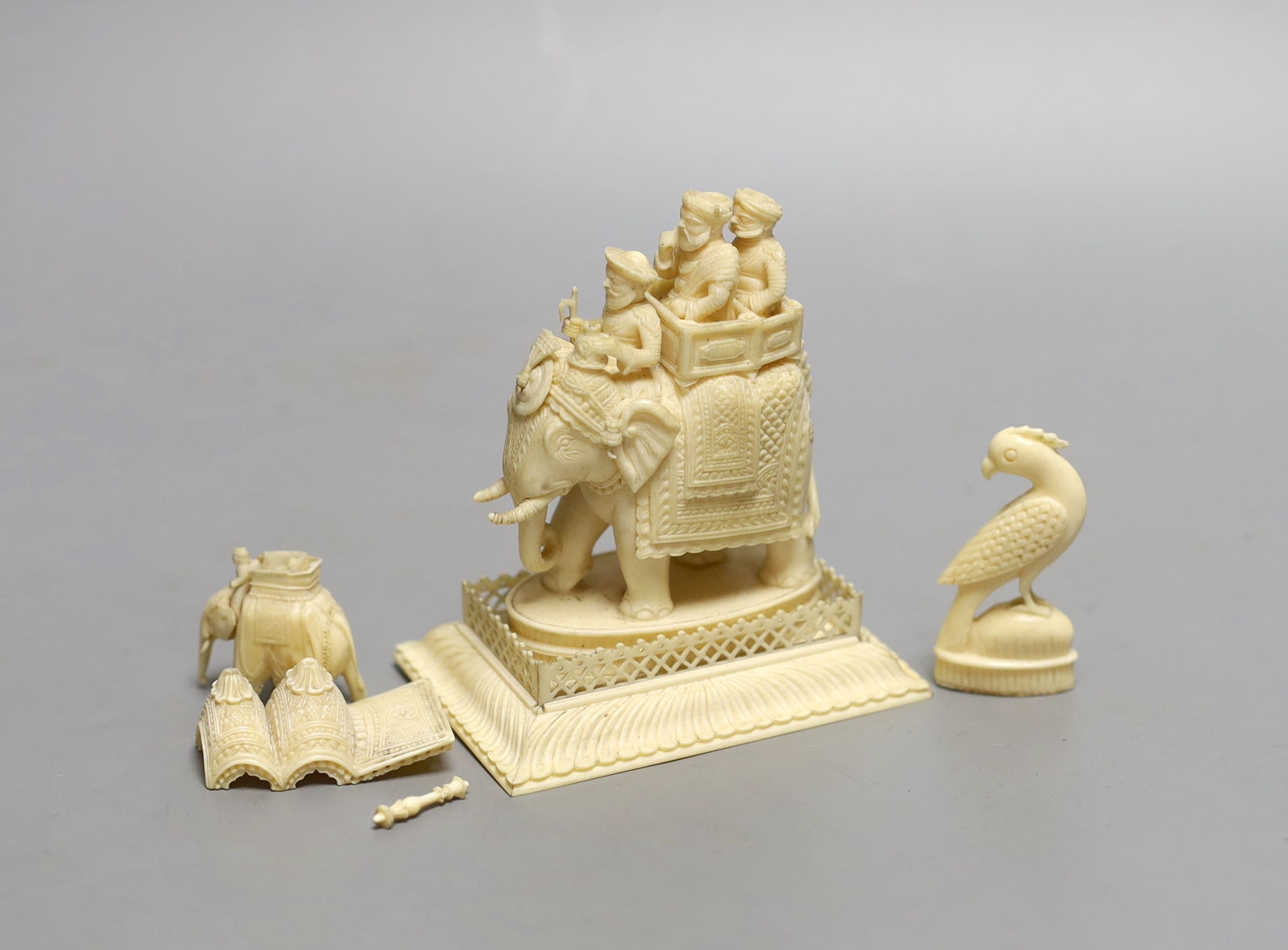 A 19th century Indian carved ivory of figures on a caparisoned elephant, 8.5cm tall, and two other small ivory carvings